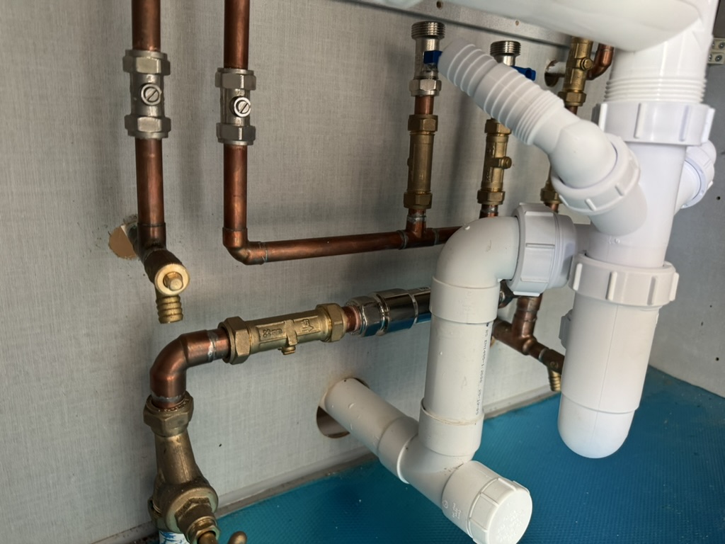 Detailed view of completed copper supply and white waste pipework